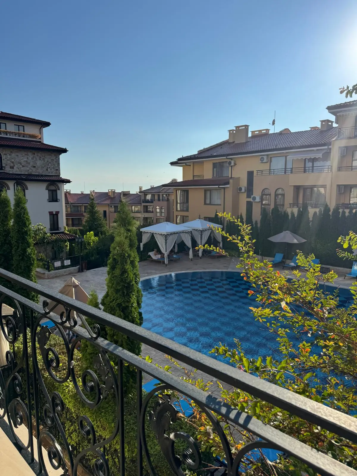 Реалната гледка от балкона на апартамента 92 м² към басейна и комплекса.