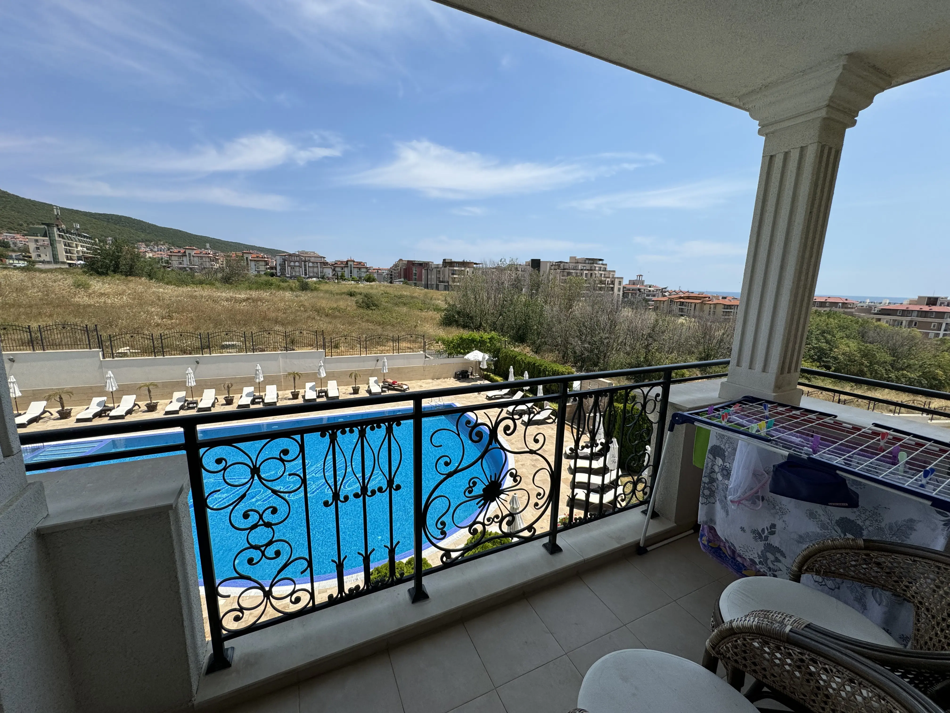 View from this apartment’s balcony towards the pool and surrounding hills.